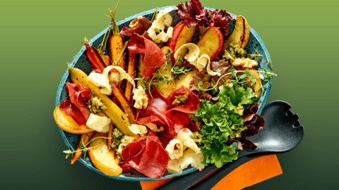 Salade met bresaola, geroosterde regenboogwortels, herfstkaas van de boerderij, walnotenpesto en gekarameliseerde appeltjes