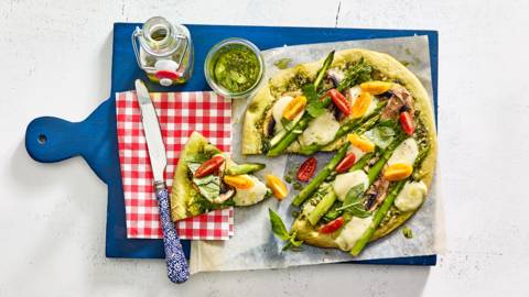 Vegetarische pizza van groente-pizzabodem met groene asperges, spinazie en champignons