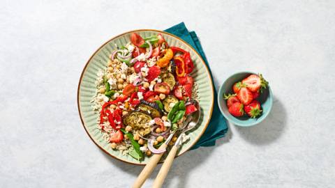 Rijst met een salade van geitenkaas, groenten en aardbeien
