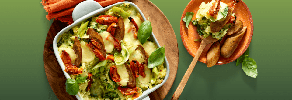 Spinazie-preistamppot uit de oven met pesto, gegratineerde mozzarella en vegetarische worst
