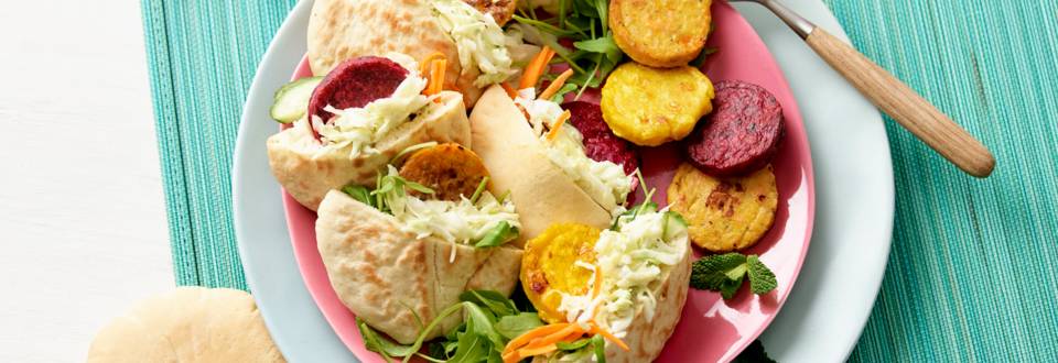 Pitabroodjes met mini-groenteburgers, wortel-gembersalade en kruidige koolsalade