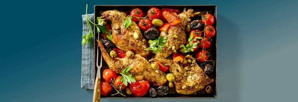 Konijnenbout uit de oven met tomaatjes, olijven en pruimen