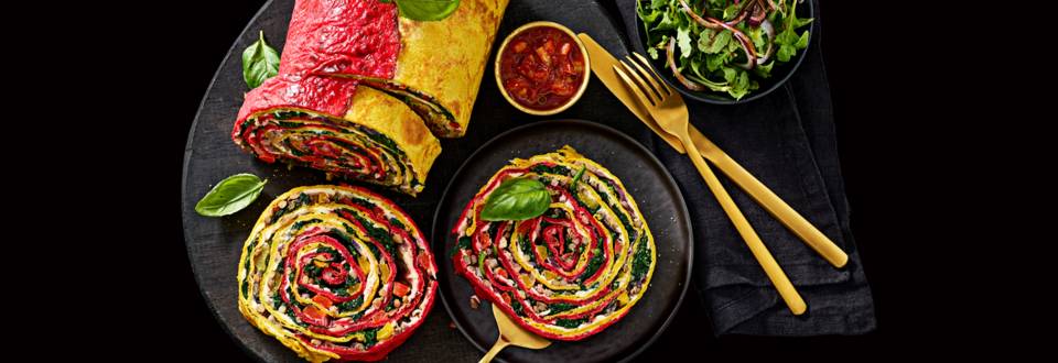 Vegetarische regenboogrollade van groenten-pannenkoeken met zoetzure tomaten-paprikasaus