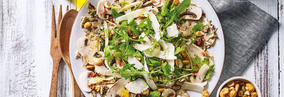 Frisse salade van gemarineerde champignons, rucola en noten