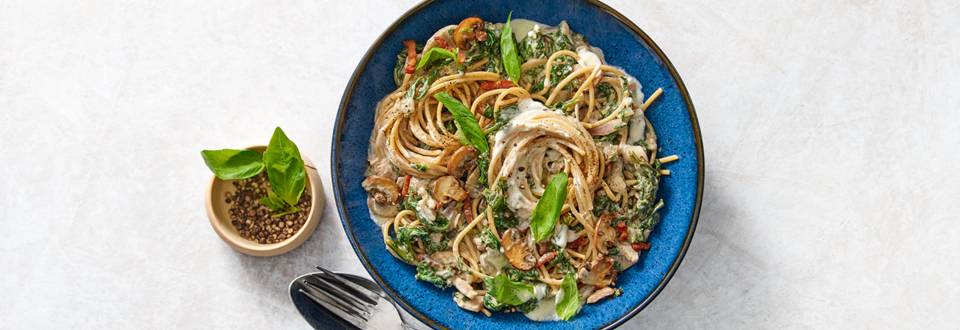 Volkoren spaghetti met spinazie, champignons, spekjes en kruidenroomkaas